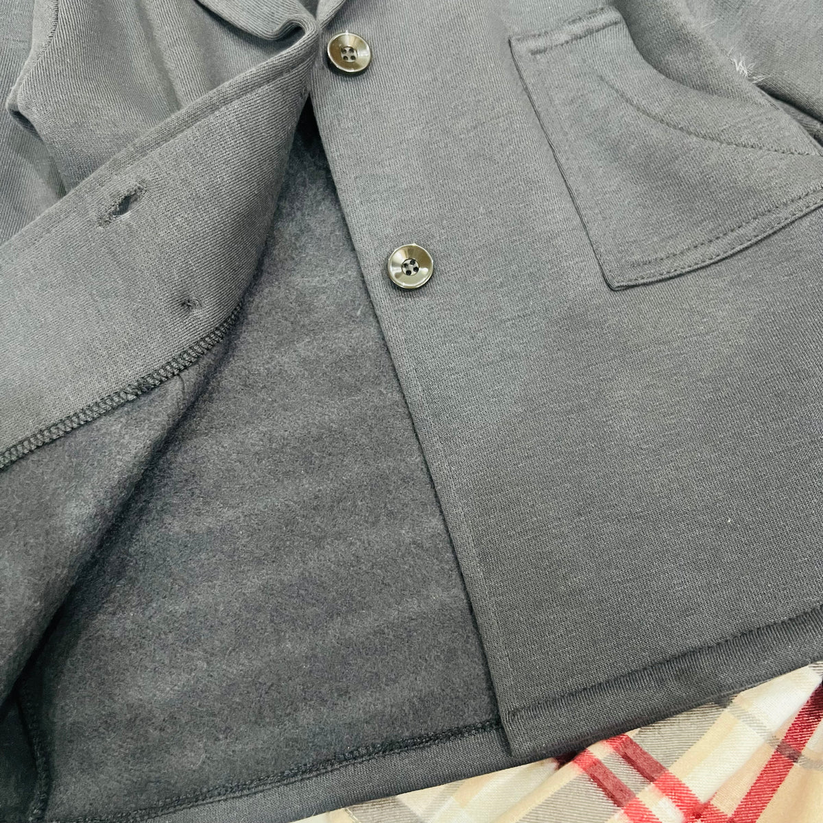 "Classy charcoal  grey trench-style blazer jacket dress paired with a beige plaid skirt."
 "Stylish girls' 2-piece layered outfit set featuring a double-breasted  charcoal grey coat and plaid pleated skirt."fleece stuff winter