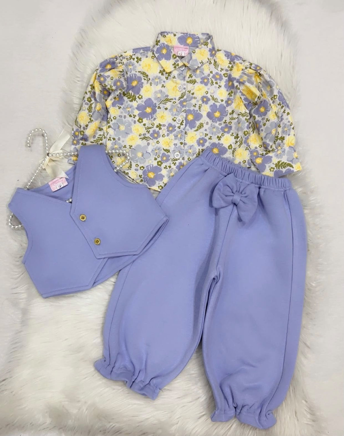 Multi-piece baby or toddler girl outfit set featuring a floral print long-sleeve collared shirt, a lilac waistcoat vest, and matching lilac cuffed trousers with a bow detail fleece winter stuff