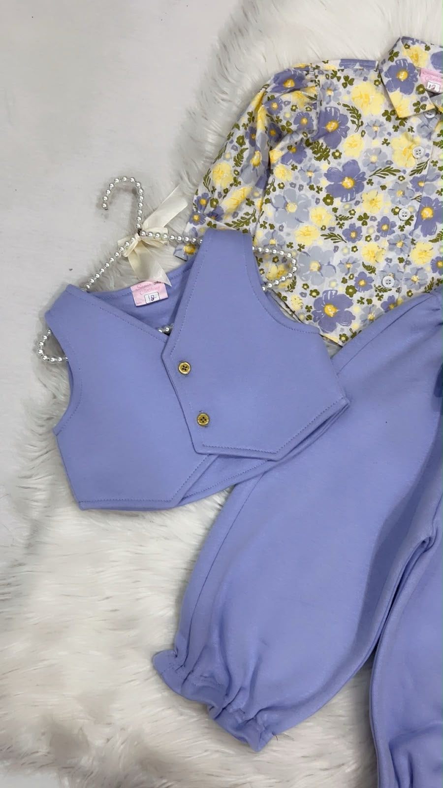 Multi-piece baby or toddler girl outfit set featuring a floral print long-sleeve collared shirt, a lilac waistcoat vest, and matching lilac cuffed trousers with a bow detail fleece winter stuff