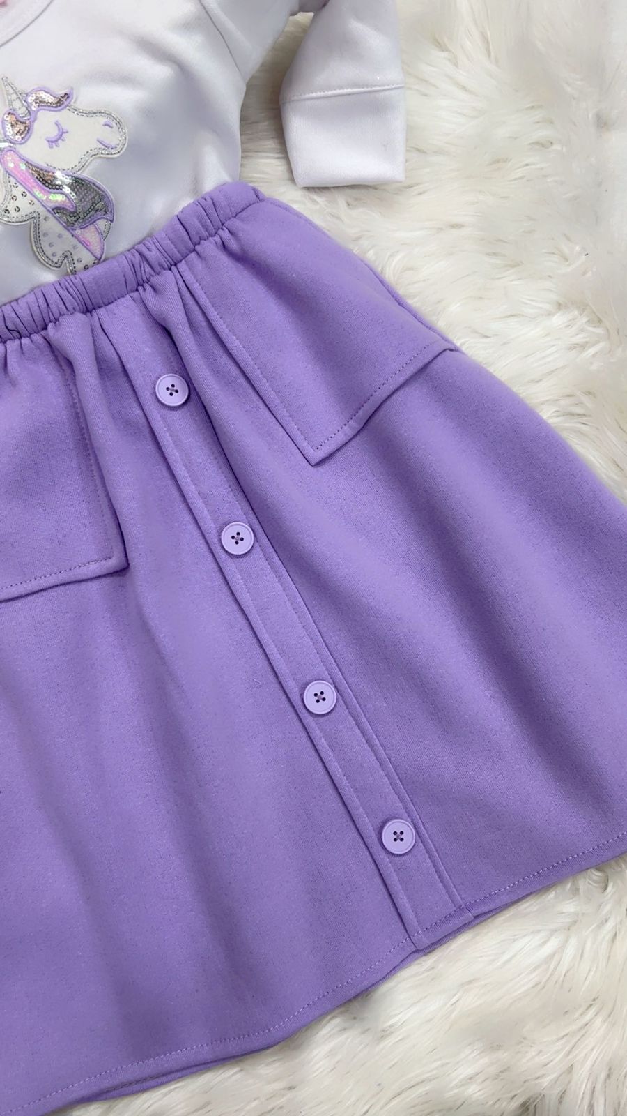 Two-piece girl's outfit featuring a white long-sleeve top with a unicorn graphic and a button-front lilac skirt fleeced stuff