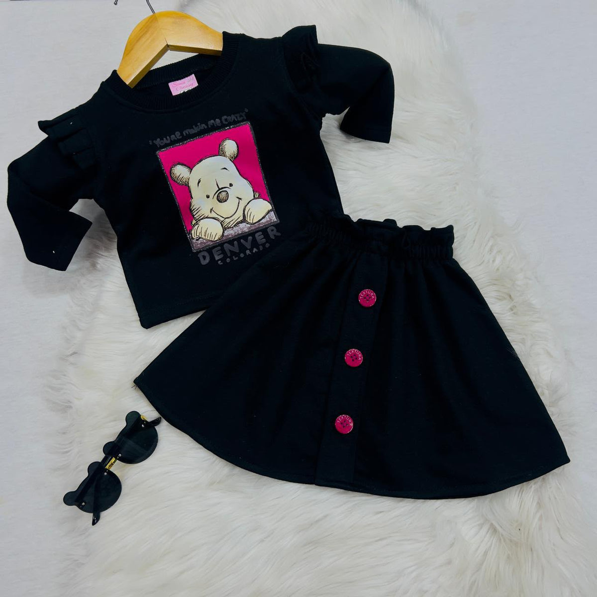 A ruffled-shoulder graphic sweatshirt paired with an A-line skirt with pink accent buttons 2000 2200 fleece winter stuff