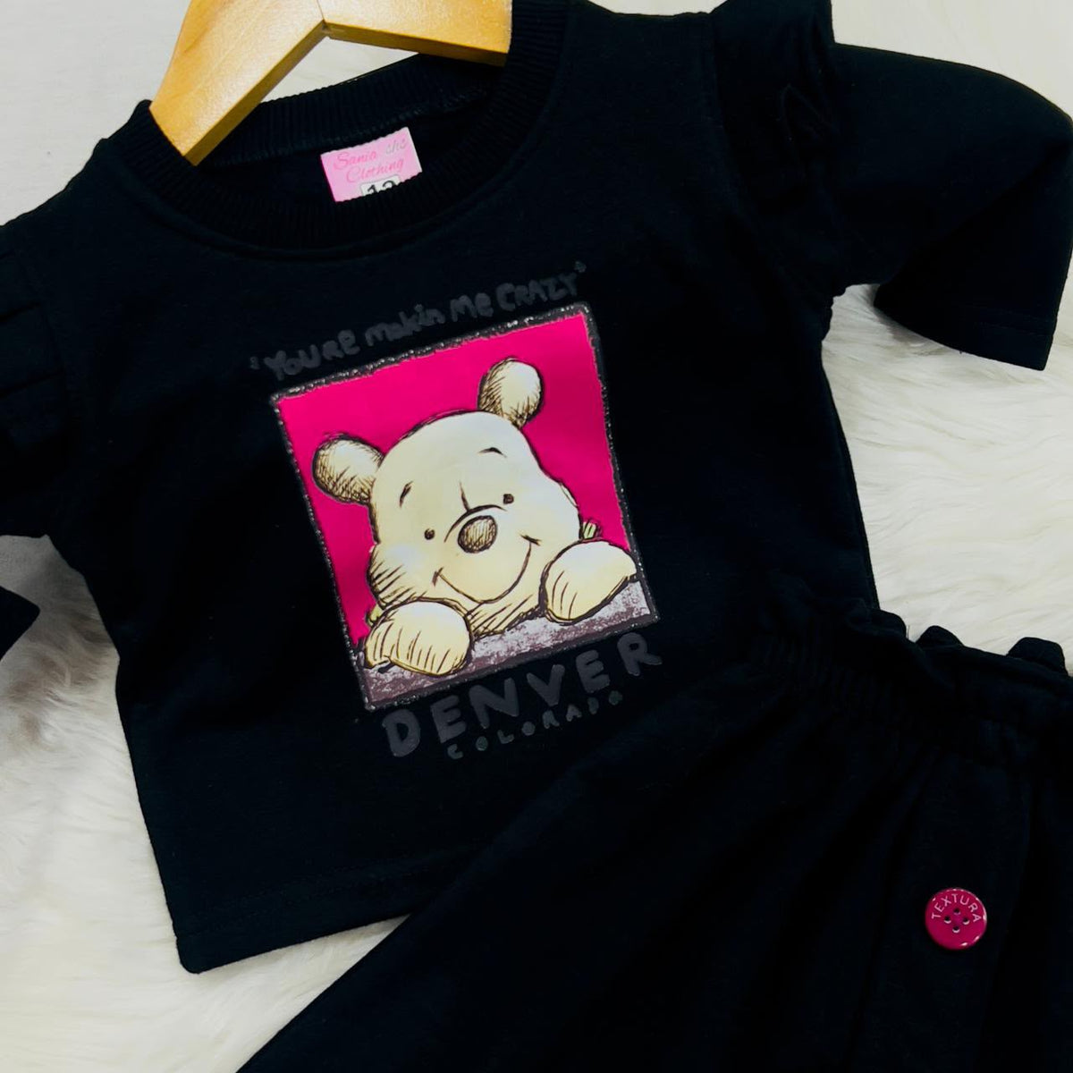 A ruffled-shoulder graphic sweatshirt paired with an A-line skirt with pink accent buttons 2000 2200 fleece winter stuff